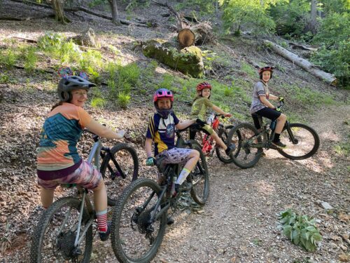 Group of 4 riders stopped for photo on mountain bikes